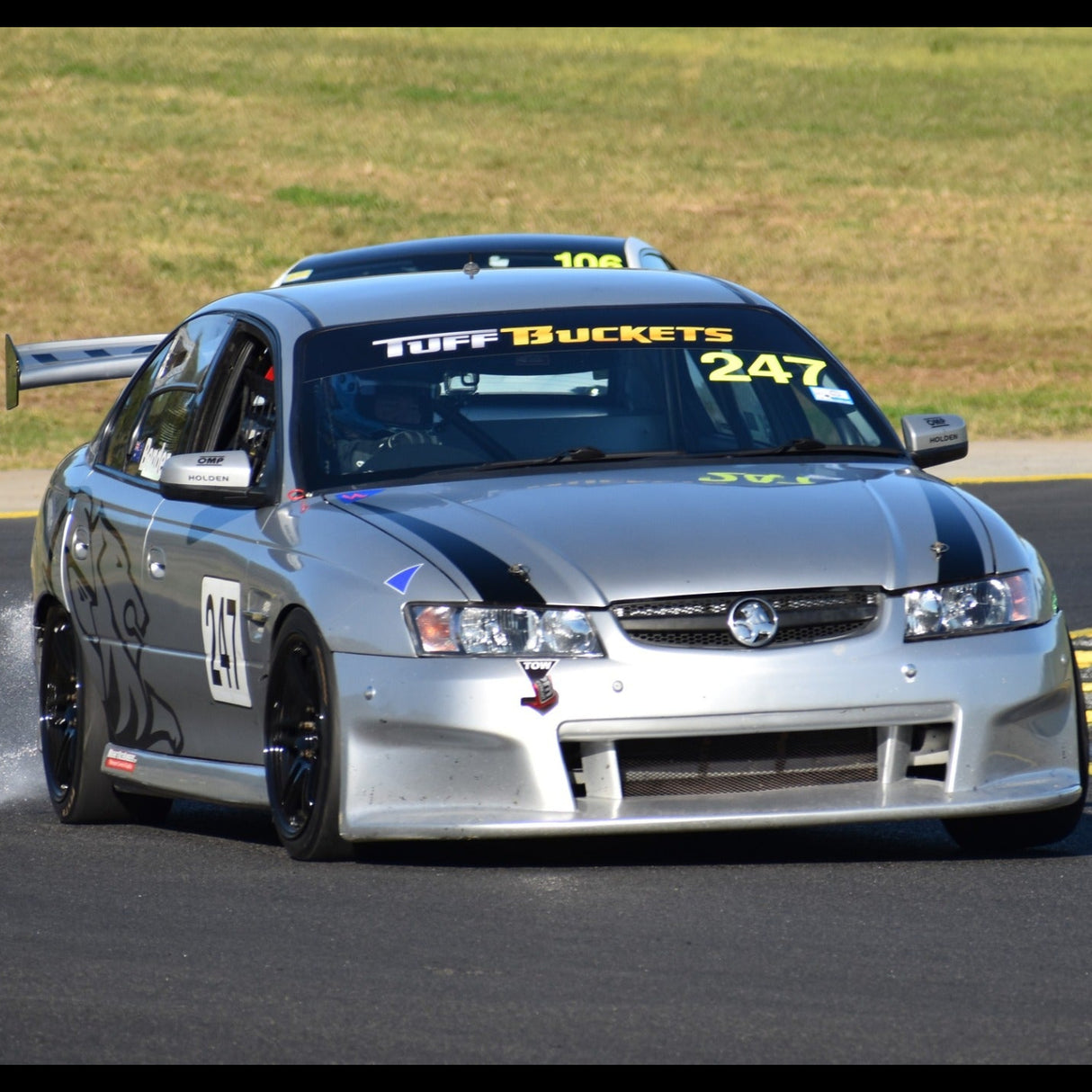 Silver race car on a track with visible branding